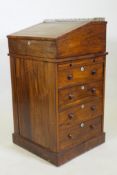 A Victorian rosewood davenport desk, with three quarter gallery and covered inkwell compartment,