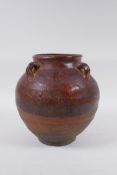 A antique glazed terracotta jar with four lug handles, 20cm high