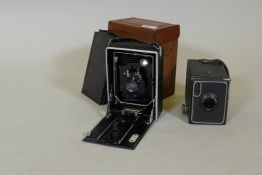 An antique camera, the lens inscribed Topaz Boyer, Paris, 15cm high, with plates and leather case,