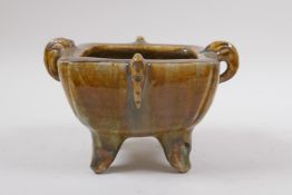 A Chinese slip glazed pottery censer with two handles, impressed ring mark to base, 17 x 14cm,