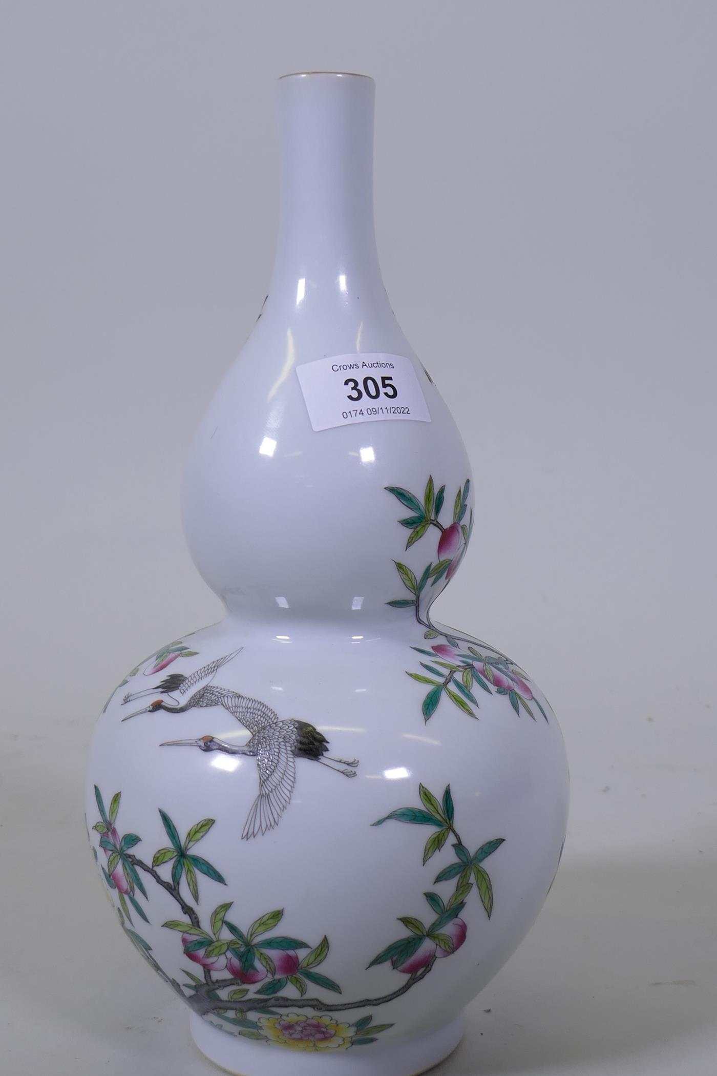 A Chinese double gourd shaped porcelain vase with enamel decoration depicting storks amongst peach - Image 2 of 4