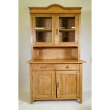 A C19th continental pine dresser, the upper section with two glazed doors, the base with two drawers