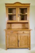 A C19th continental pine dresser, the upper section with two glazed doors, the base with two drawers