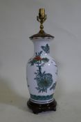 A porcelain table lamp with butterfly and lotus flower decoration in the Chinese manner, 57cm high