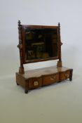 A C19th bowed front mahogany swing toilet mirror, the bevelled glass between ring turned supports,