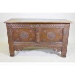An C18th continental oak coffer, two panelled front with chip carved decoration under a sea scroll