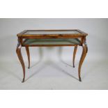 A French style mahogany bijouterie cabinet with shaped top, raised on cabriole supports with brass