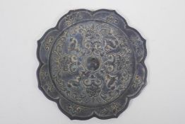A Chinese bronze lotus flower shaped mirror with raised duck and flower decoration, 21cm diameter