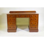 A C19th mahogany nine drawer kneehole desk with original locks and turned wood handles, raised on