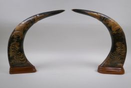 A pair of oriental carved horns decorated with tigers and dragons, 36cm high