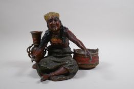 A painted spelter figure of a seated Moorish girl, 22cm wide, 18cm high