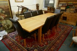 A contemporary golden oak dining table, with pull out ends, central fold out leaf, raised on