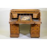 A Victorian mahogany roll top pedestal desk, the upper section fitted with drawers and pigeon