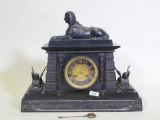 A C19th Egyptian Revival polished slate mantel clock, with patinated bronze mounts, the ormolu