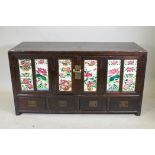 An antique Chinese stained elm side cabinet with two cupboards fitted with folding doors, inset with