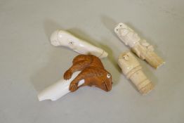 Three bone walking stick handles, one carved as a monkey, another as a hand gripping a serpent,