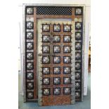 A large oriental door in frame with white metal decorative mounts and inset with amber style shards,