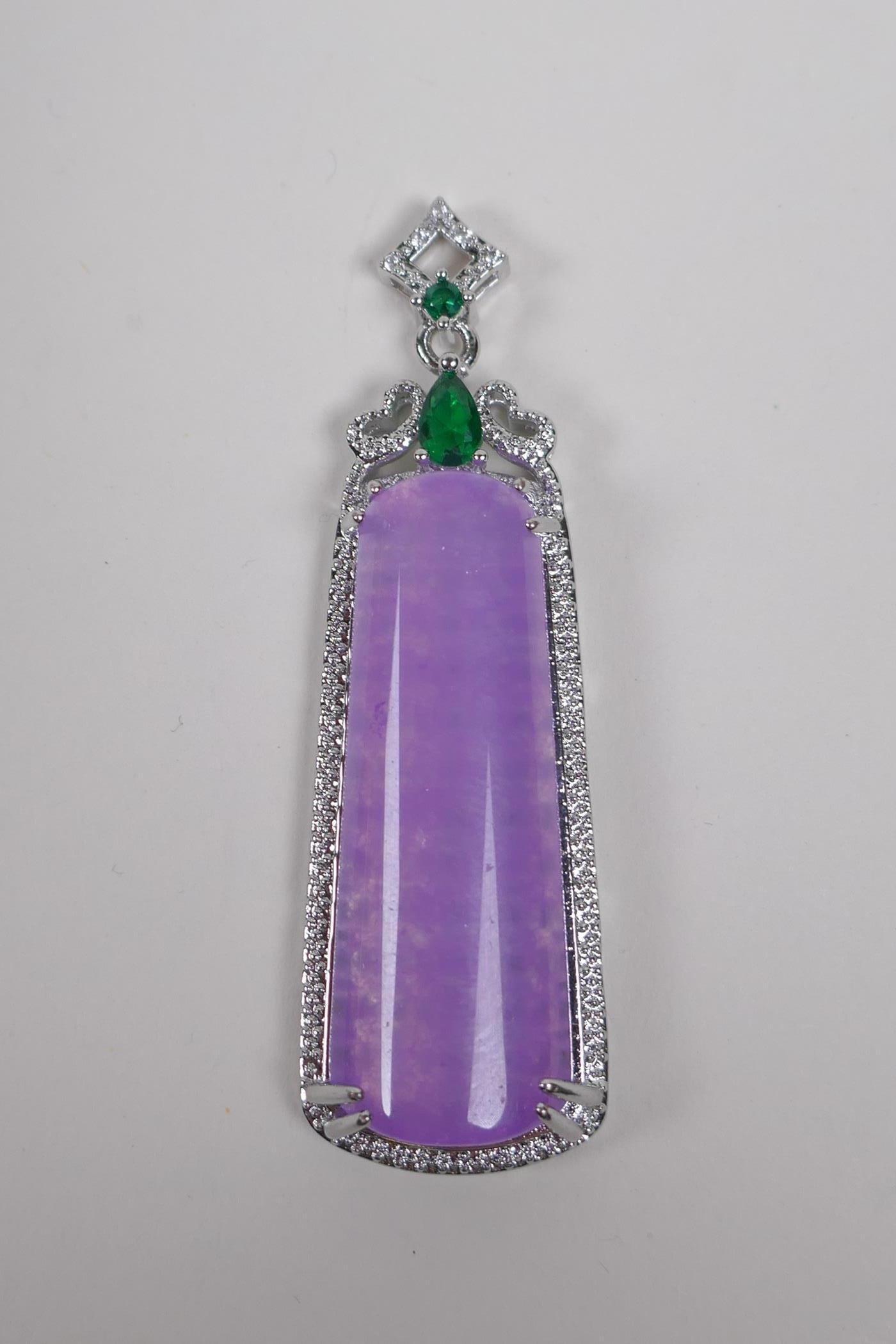 A white metal pendant set with a large amethyst coloured stone, cubic zirconia and green stones, 6cm