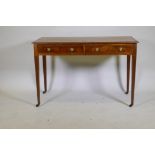 A C19th inlaid mahogany two drawer writing table with brass ring handles raised on square tapering