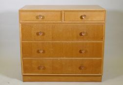 A mid century Meredew oak veneered chest of two over three drawers, raised on a plinth base, AF some