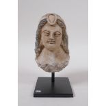 A Ghandhar style painted clay female head bust, mounted on a display stand, 14cm high