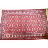 An antique red ground wool Bokhara rug, 240 x 156cm