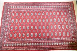 An antique red ground wool Bokhara rug, 240 x 156cm