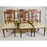 A set of six Edwardian oak dining chairs with carved and pierced lyre backs, turned supports and