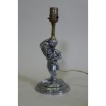 An antique chrome plated figural lamp in the form of a dwarf bearing an urn, converted to