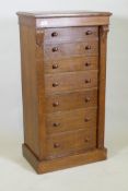 An oak Wellington chest of seven graduated drawers with  carved corbels and locking bark, raised