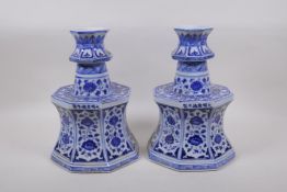 A pair of blue and white porcelain candlesticks of octagonal form with decorative floral panels,