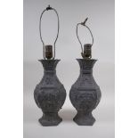 A pair of Chinese pewter lamps decorated with mythical creatures and auspicious symbols, 35cm high