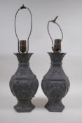 A pair of Chinese pewter lamps decorated with mythical creatures and auspicious symbols, 35cm high