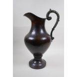 A patinated hammered copper urn with bronze handle, 39cm high