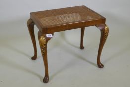 A Georgian style walnut stool with carved and parcel gilt decoration and cane seat, 56 x 41cm,