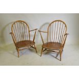 A pair of mid century Ercol beechwood hoopback elbow chairs with solid seats, 83cm