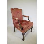 A late C19th Gainsborough chair with hump back, scroll arms, carved cabriole legs and ball and