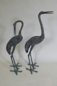 A pair of decorative metal garden cranes, largest 81cm high
