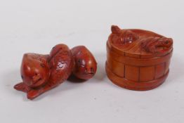 A Japanese carved boxwood netsuke in the form of three carp, and another in the form of a barrel