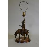 A vintage table lamp in the form of an oriental gentleman riding a mule, mounted on a wood base,