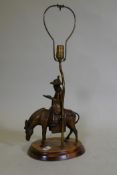 A vintage table lamp in the form of an oriental gentleman riding a mule, mounted on a wood base,