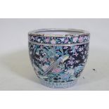 An antique Chinese famille noire ceramic jardiniere, decorated with exotic birds and flowers, 33cm