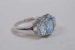 A 925 silver ring set with three oval blue topaz stones and cubic zirconia, size P