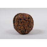A Chinese carved walnut kernel with figural decoration, 4cm diameter