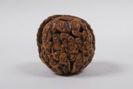 A Chinese carved walnut kernel with figural decoration, 4cm diameter