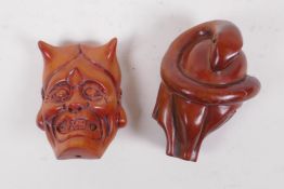 A Japanese carved boxwood netsuke in the form of an oni mask, and another carved in the form of a
