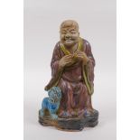 A sancai glazed porcelain figure of Lohan and a fo dog, 21cm high