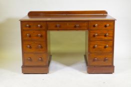 A C19th mahogany nine drawer kneehole desk with original locks and turned wood handles, raised on
