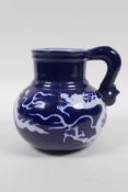 A Chinese blue ground porcelain wine jug with white underglaze dragon decoration, 15cm high