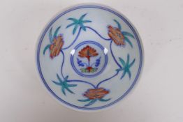 A Doucai porcelain tea bowl with raised lotus flower design to the exterior and floral decoration to